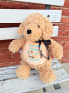 Beige dog with a personalized message on a wooden surface